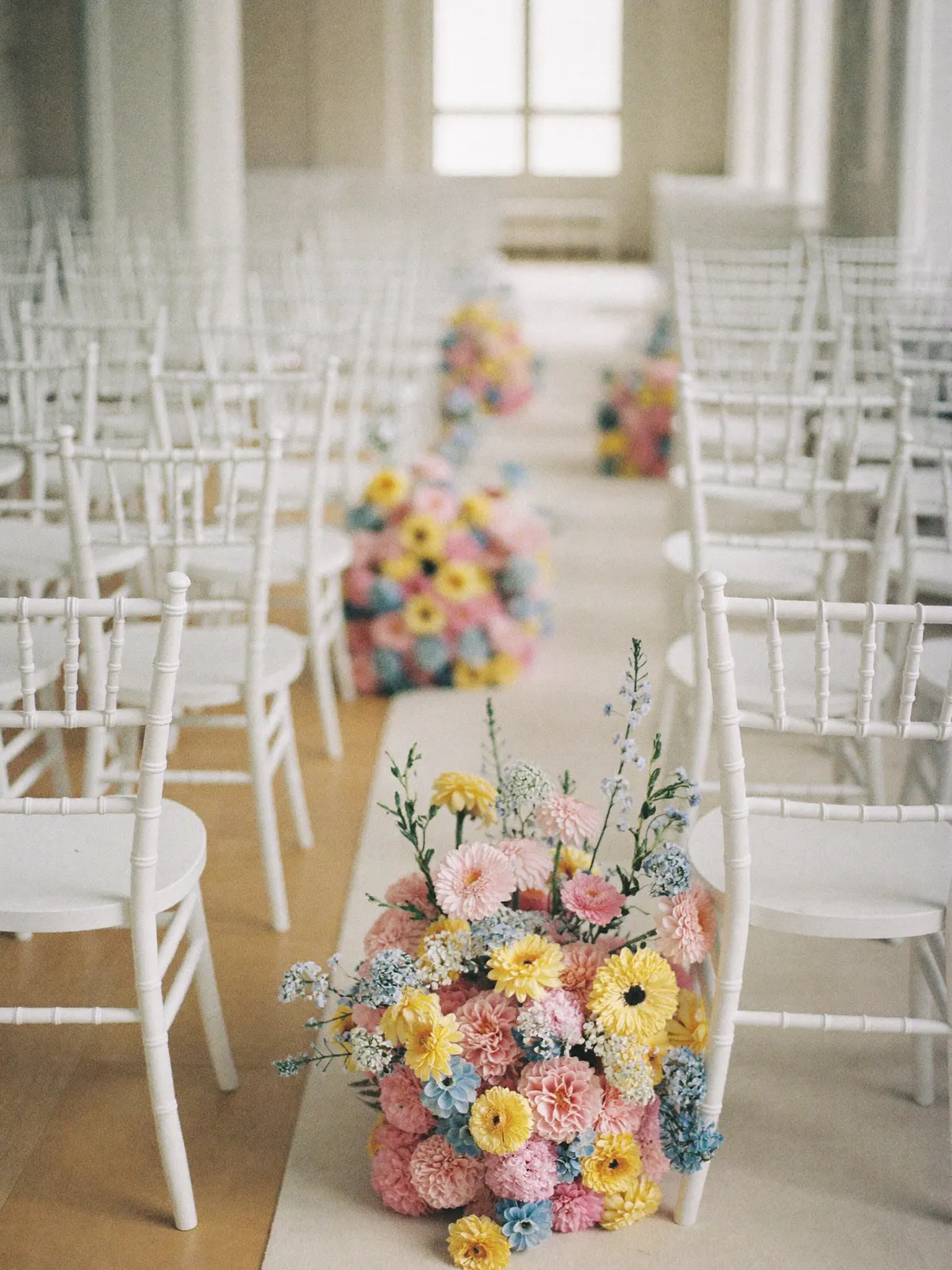 Rows of ceremony chairs with aisle florals