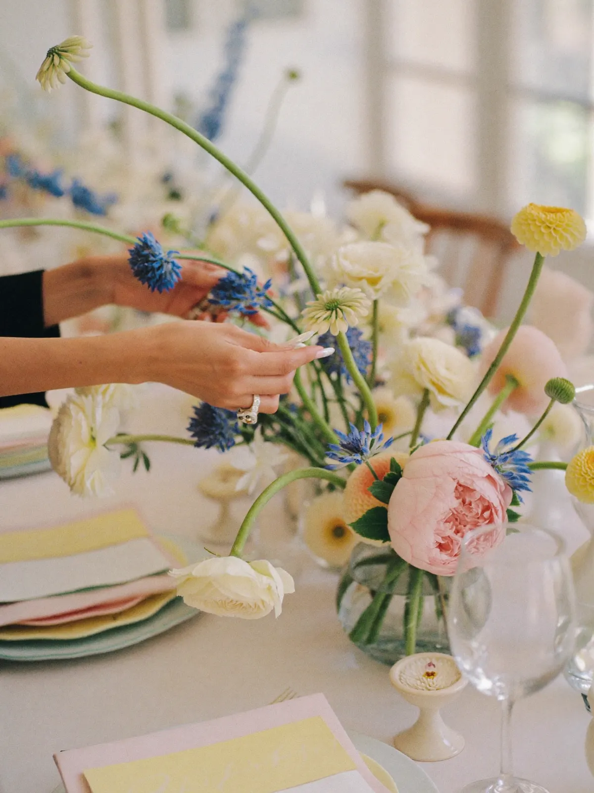 Hands arranging a floral centrepiece